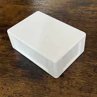 Weißes Kunststoffgehäuse auf Holztisch
