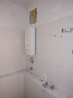 Baustelle in einem Badezimmer mit Fliesen und Elektroinstallation