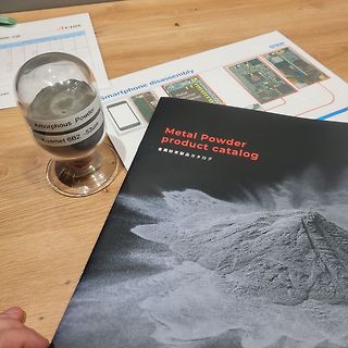 Sanduhr mit Metallpulver und Produktkatalog