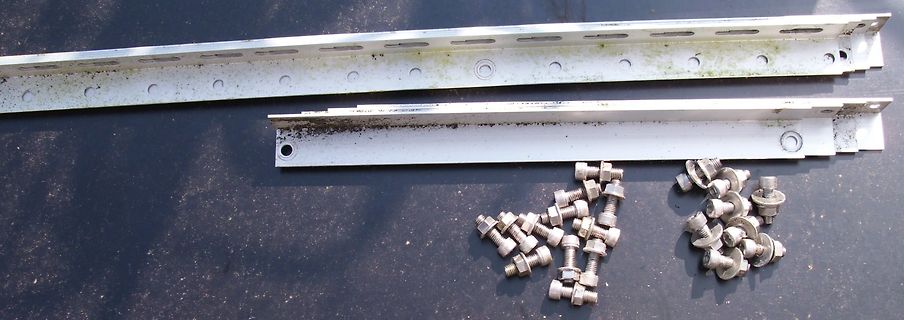 Metallschienen und Schrauben auf dunklem Untergrund