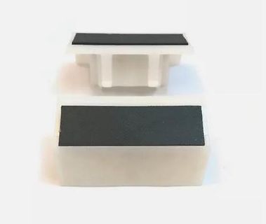 Zwei weiße Kunststoffbauteile mit schwarzer Oberfläche