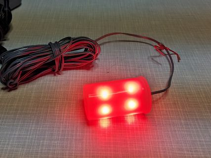 Rote LED-Leuchte mit Kabeln auf Tisch