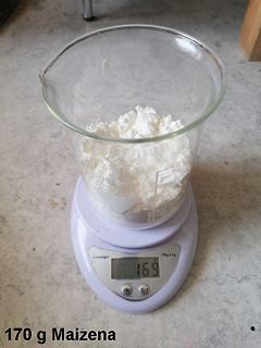 Becherglas mit weißem Pulver auf digitaler Waage