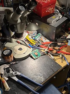Werkstatt mit Mikroskop, Werkzeugen und Leiterplatte