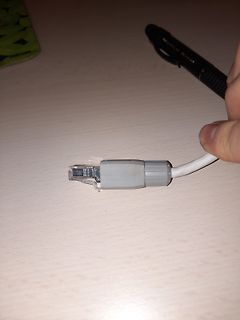 Hand hält ein Ethernet-Kabel mit RJ45-Stecker und Stift
