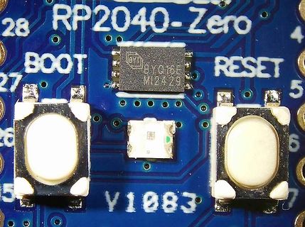 Nahaufnahme einer RP2040-Zero Platine mit Taster und IC