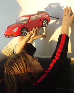Person hält Spielzeugauto hoch