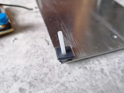 Weißer Kunststoffstift auf Metallplatte