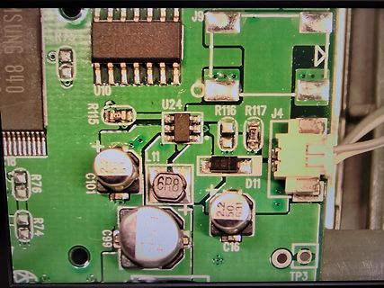 Nahaufnahme einer grünen Leiterplatte mit elektronischen Bauteilen