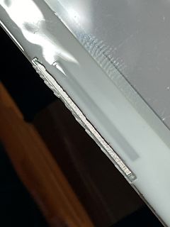 Nahaufnahme einer Metallkante mit einer Feder