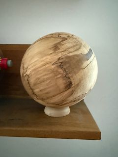 Holzkugel auf einem Holzsockel