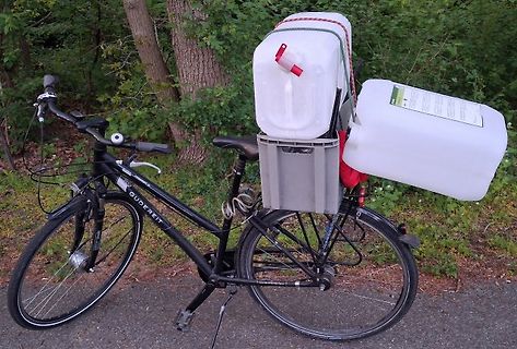 Fahrrad mit Wasserkanistern auf einem Gepäckträger