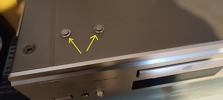 Oberseite eines Denon CD-Players mit markierten Schrauben