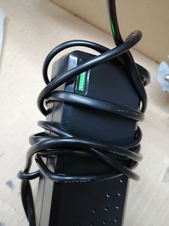 Schwarzes Netzteil mit umwickeltem Kabel