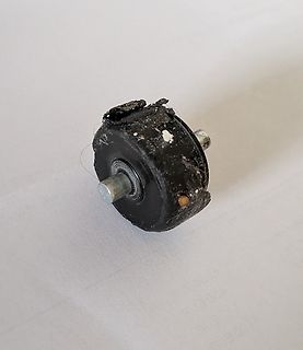 Beschädigtes schwarzes Bauteil mit Metallstiften