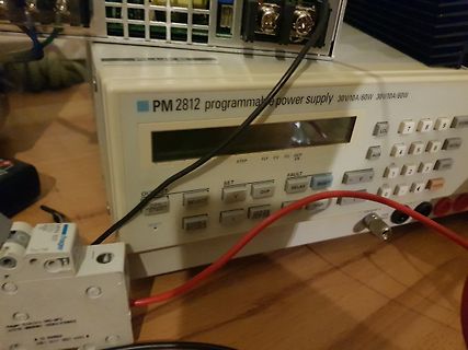 Programmierbares Netzteil und Bauteile auf Holztisch