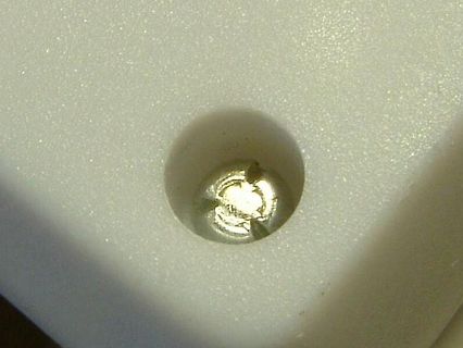 Metallischer Gegenstand in einer kreisförmigen Vertiefung