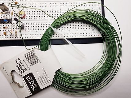 Breadboard mit Bauteilen und Rolle grüner Bindedraht
