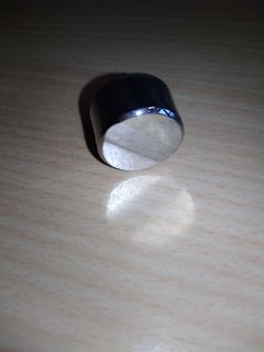 Metallischer Zylinder auf Holzoberfläche