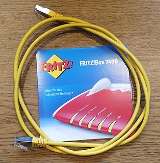 Gelbes Netzwerkkabel und FRITZ!Box 7490 Verpackung