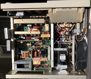 Innenansicht eines geöffneten Netzteils mit Platinen und Spulen