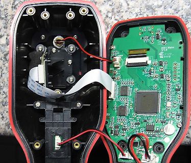 Geöffnetes elektronisches Gerät mit Leiterplatte und Flachbandkabel
