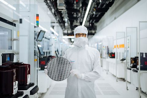 Person in Reinraum hält Silizium-Wafer