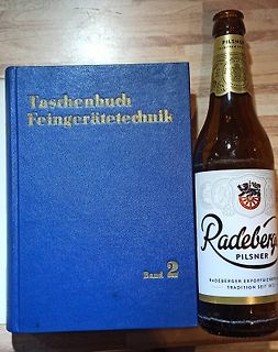 Buch und Bierflasche auf Holztisch