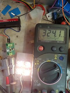 Multimeter und elektronischer Aufbau auf Werkstattunterlage