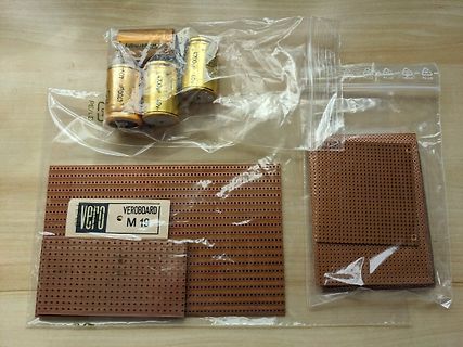 Elektrobauteile und Lochrasterplatten in Plastikbeuteln