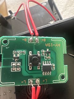 Grüne Leiterplatte mit roten Kabeln und elektronischen Bauteilen