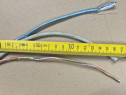 Kabel und Maßband auf Untergrund