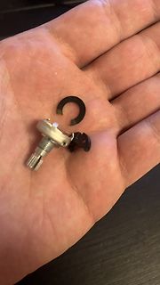 Kleines Bauteil und schwarzer Ring in einer Hand