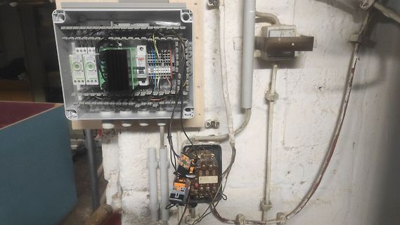 Offener Sicherungskasten und elektrische Installation an Wand