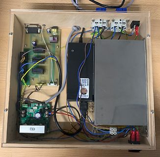 Elektronikaufbau in einem Holzgehäuse mit Platinen und Netzteilen