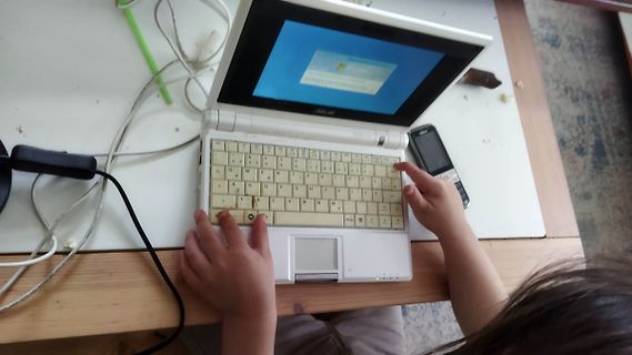 Person bedient einen kleinen Laptop