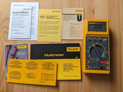 Fluke Multimeter und Dokumentation auf Holzuntergrund