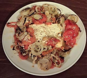 Tomaten mit Zwiebeln und Feta auf einem Teller