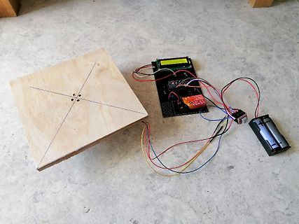 Elektronik-Aufbau mit Display, Leiterplatte und Batterie auf Holzbrett