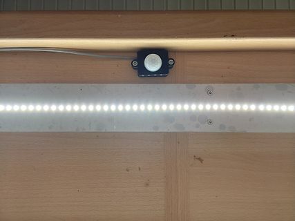 Bewegungsmelder und LED-Streifen an Holzpaneel
