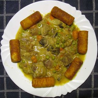 Teller mit Eintopf und Teigrollen
