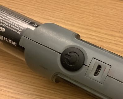 Nahaufnahme eines grauen elektronischen Geräts mit Power-Button und USB-Port