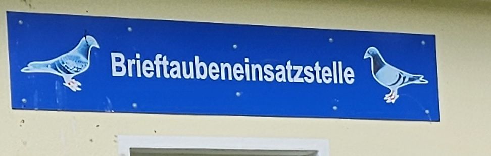 Blaues Schild mit Tauben und Text