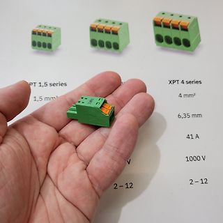 Hand hält Klemmenblock vor Datenblatt