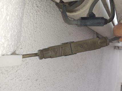 Kabel mit Steckverbindung an weißer Wand