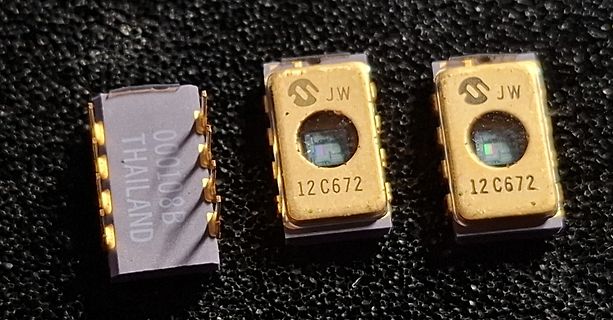 Drei optische Bauteile mit Goldgehäuse