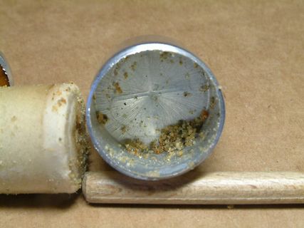 Metallrohr mit Rückständen und Holzstäbe