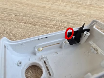 Innenansicht eines weißen Kunststoffgehäuses mit schwarzem Klebeband