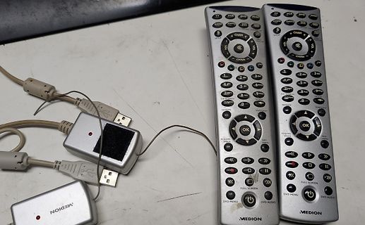 Zwei Fernbedienungen und USB-Adapter auf einem Tisch