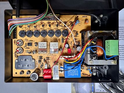 Innenansicht eines elektronischen Geräts mit Leiterplatte und Transformator